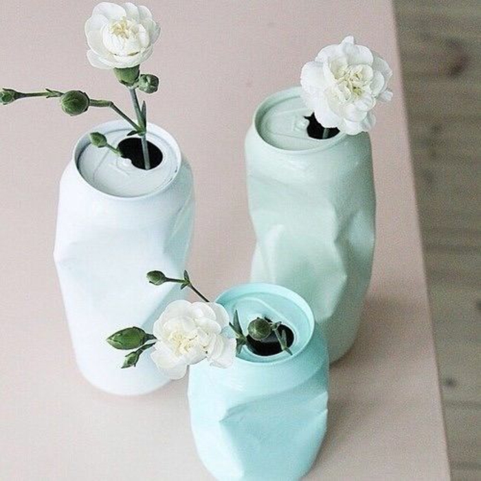 himmelsblaue vasen aus dosen mit weißen blumen