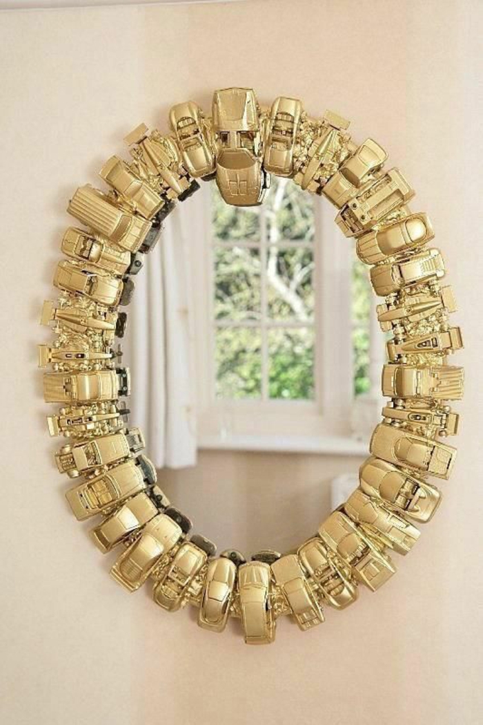 ovaler spiegel mit goldenem rahmen aus kleinen autos