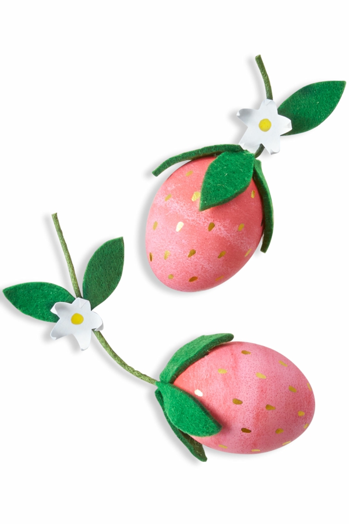 rote lustige Eier mit Tropfen, um wie Erdbeeren zu aussehen mit einen weißen Blüten