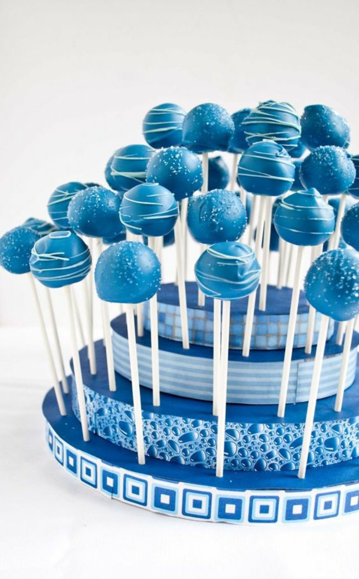 cake pops mit blauer glasur dekoriert mit weißer schokolade