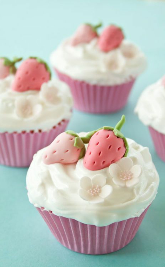 muffins mit weißer sahne, kleine blümchen und erdbeeren aus fondant