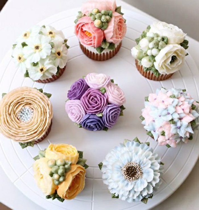 muffins dekoriert mit verschiedenen blumen aus sahne