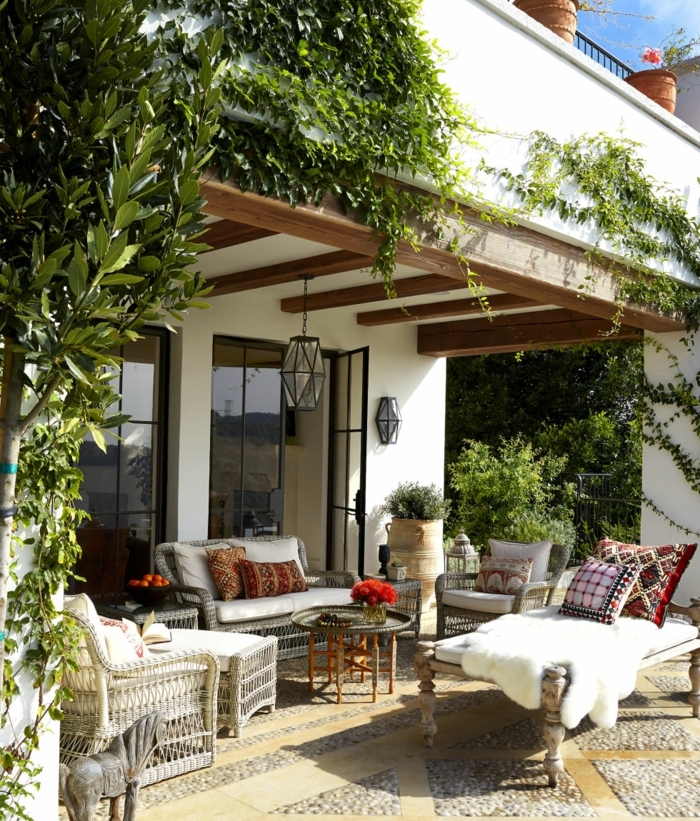terrassengestaltung ideen gemütliche terrasse sofa sessel pelz teppich kissen blumen deko pflanze