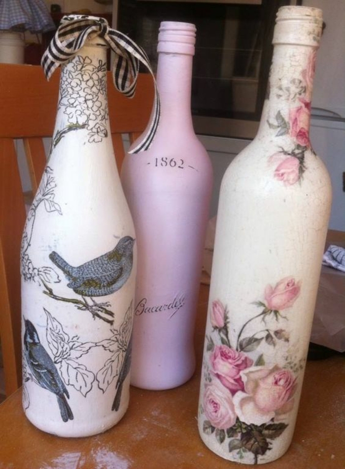drei flaschen mit servietten mit pinken blumen und grauen vögeln und einem grauen spatz 