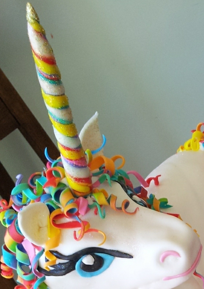 ein weißes einhorn mit einem regenbogenfarbenen horn - idee für eine einhorn torte 
