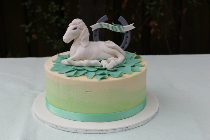eine grüne torte mit einem weißen einhorn - idee für einhorn kuchen 
