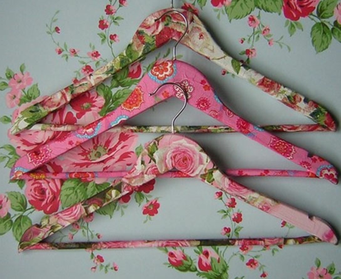 hier sind drei schöne kleiderhalter mit pinken servietten ind rosen 
