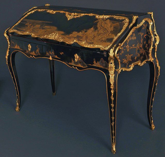 Gothic-Möbel: schwarzer schräger Schreibtisch aus Holz mit zwei kleinen Schubladen, goldene Ornamente