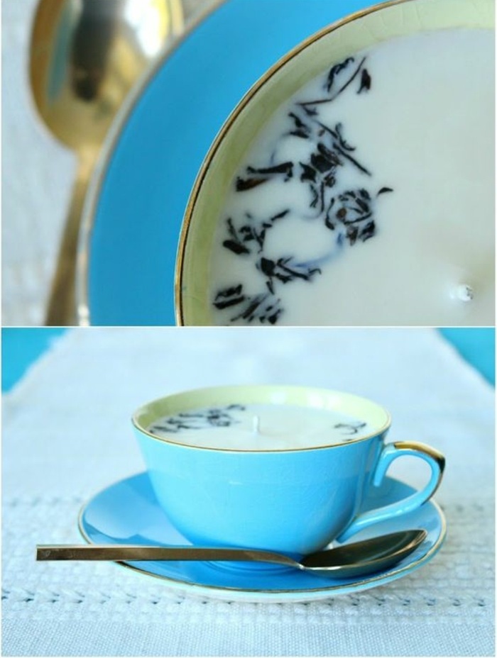 blaue teetasse mit weißer kerze mit schwarzen elementen