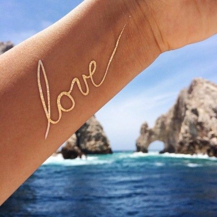 tattoo vorlagen frauen liebe mit goldenem stift schreiben tattoo am arm meer harmonie romantik