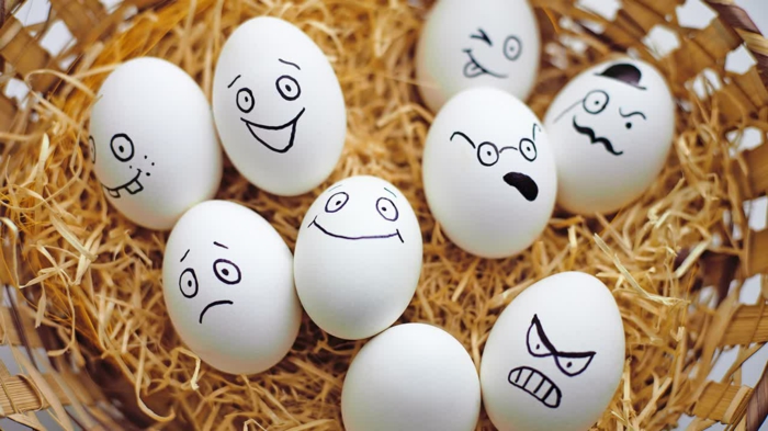 Eier lustig - Gesicher mit Filzstift bemalt mit verschiedenen Mienen - glücklich und böse