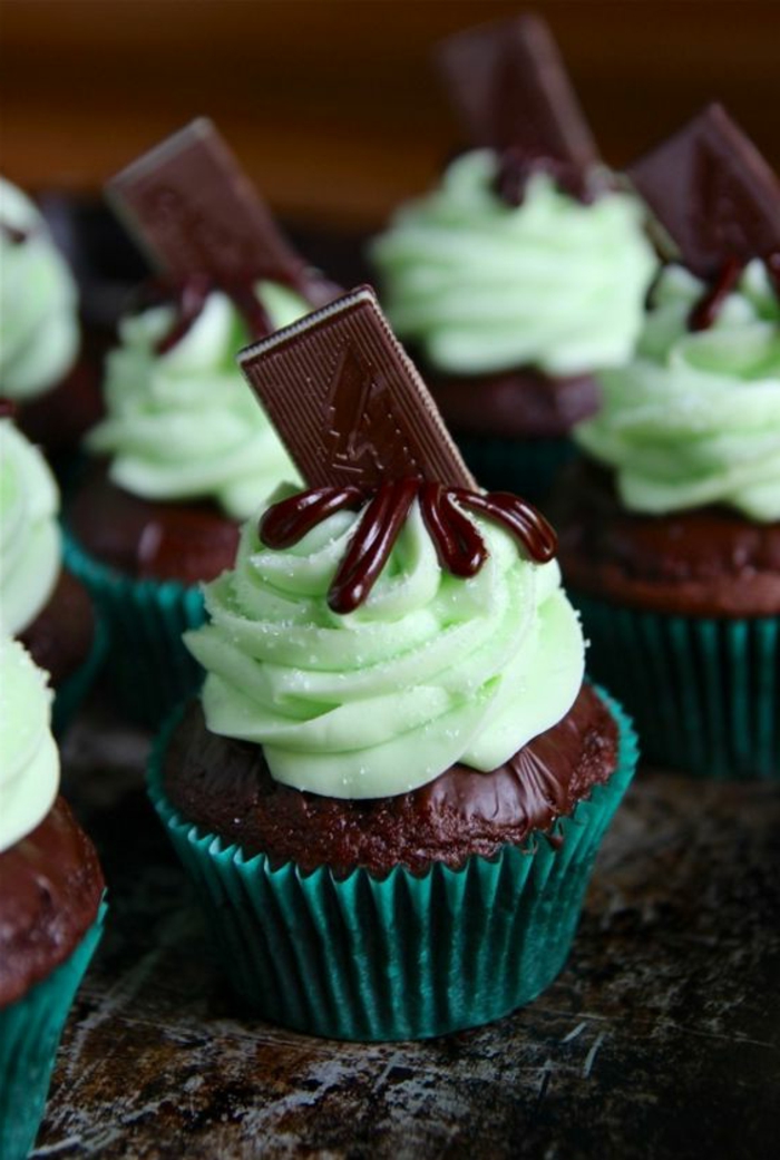 schoko-cupcake dekoriert mit grüner sahne und ein stück schokolade