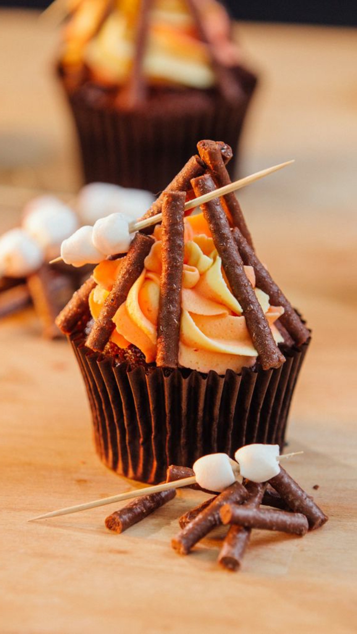 coole muffin-deko mit schokolade, oranger sahne und bonbons