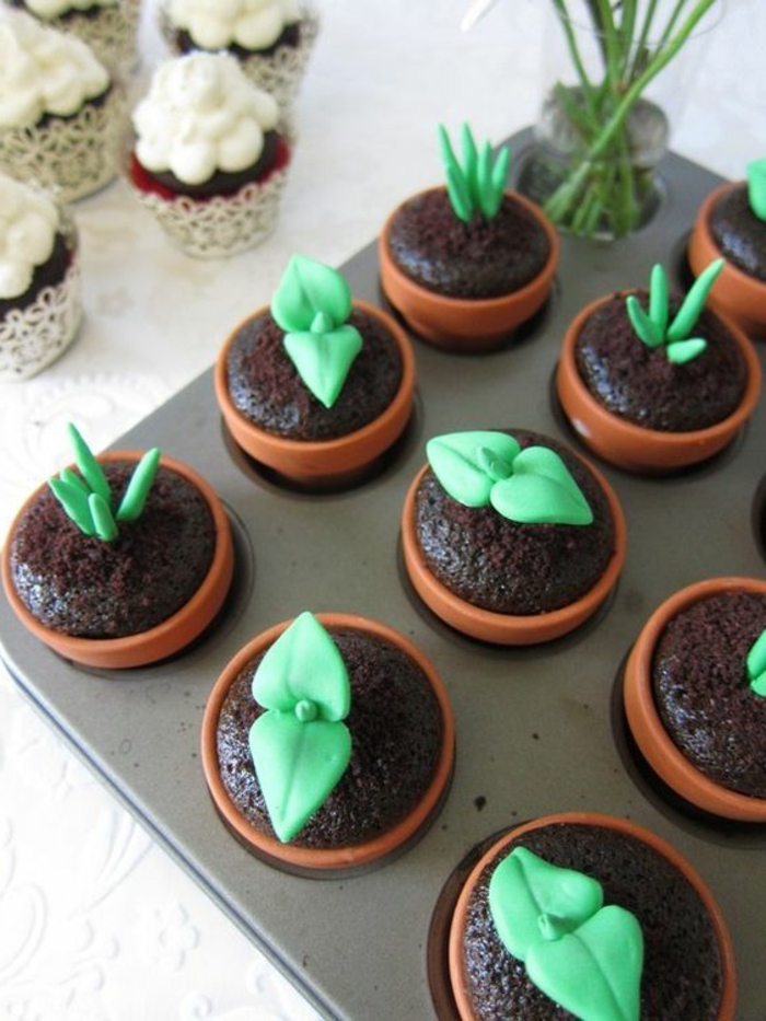 schoko-cupcakes dekoriert mit grünen blättern aus fondant
