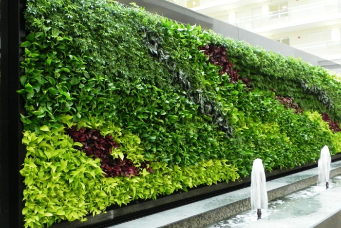 grüne Wand mit einem Springbrunnen davor - vertikaler Garten