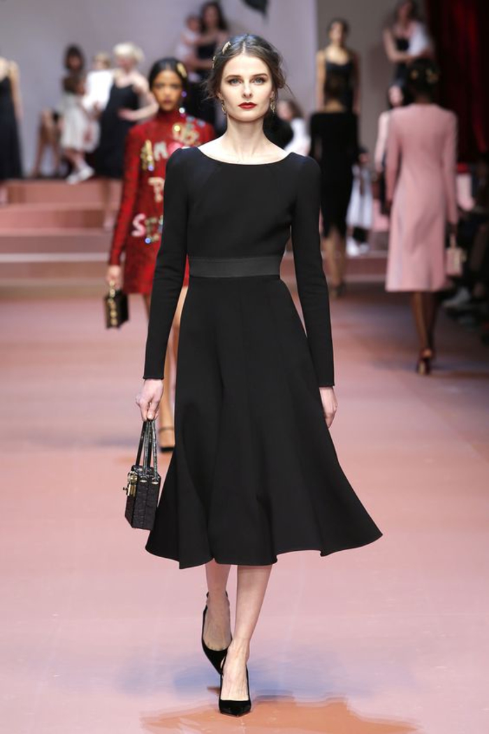 klassisches kleid in schwarz, lang, mit langen aermeln, schwarze tasche und schuhe