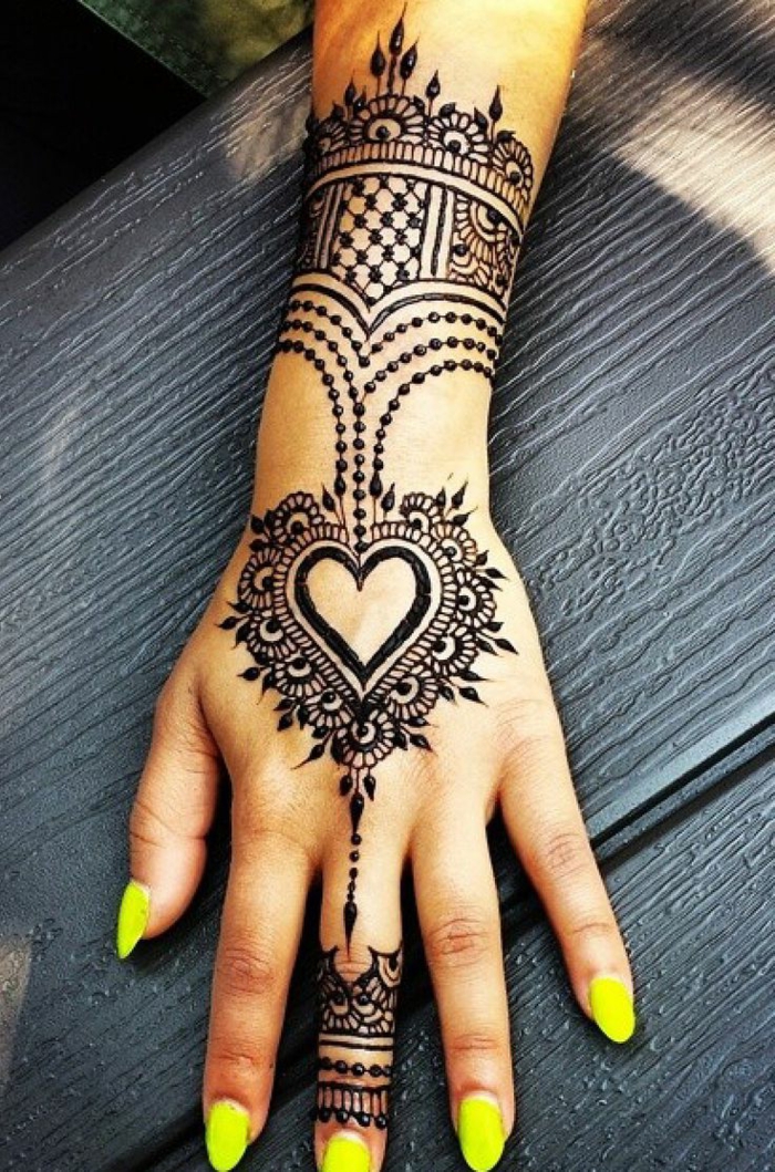 tattoo motive frau dezentes tattoo henna auf der hand von einer schönen frau gelbe nägel lackieren