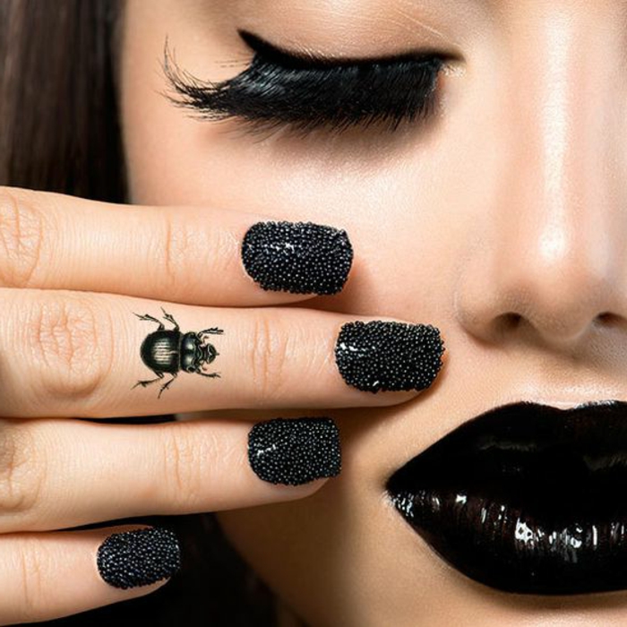 tattoo motive frau deko auf den fingern käfer nageldesign mit steinen schwarze lippen wimpern