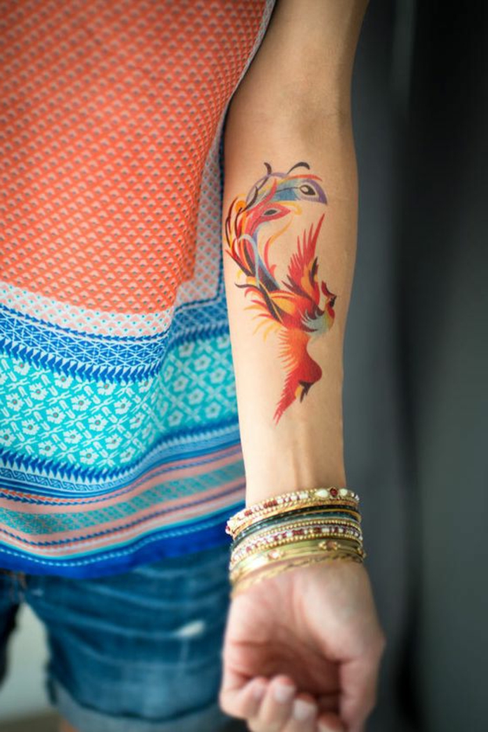kleine tattoo ideen phönih vogel auf dem arm gemalt mit bunten farben viele armbänder bunt