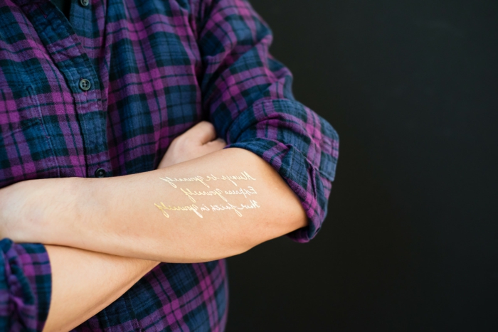 schöne tattoos goldene worte auf dem arm stehen und verschönern dem körper lila blau hemd 