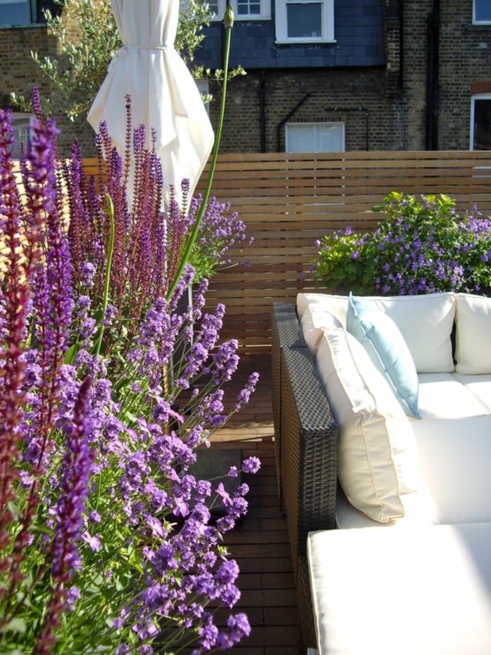 terrassengestaltung ideen sofa aus rattan weiße deko kissen weich bequem lavendel blumen lila
