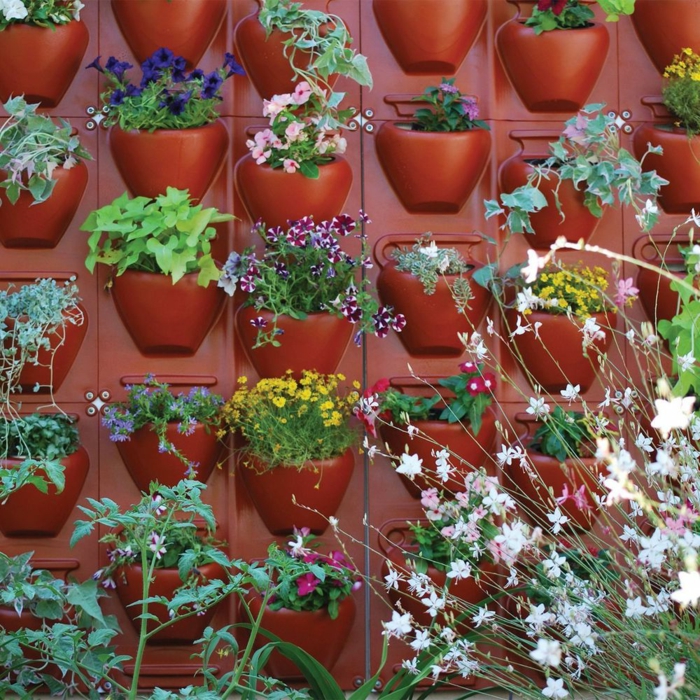 Pflanzenwand selber bauen - rote eingebaute Blumentöpfe aus Kunststoff