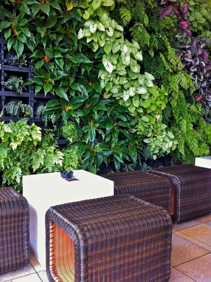ein Cafe wo sich ein vertikal Garten befindet in grüner und lila Farbe