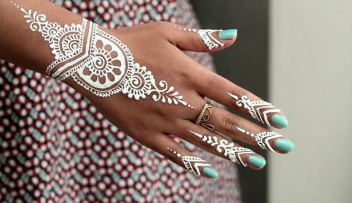 Henna Farbe: weißes Henna, Frau mit buntem Kleid mit Tattoo am Finger und Tattoo am Handgelenk