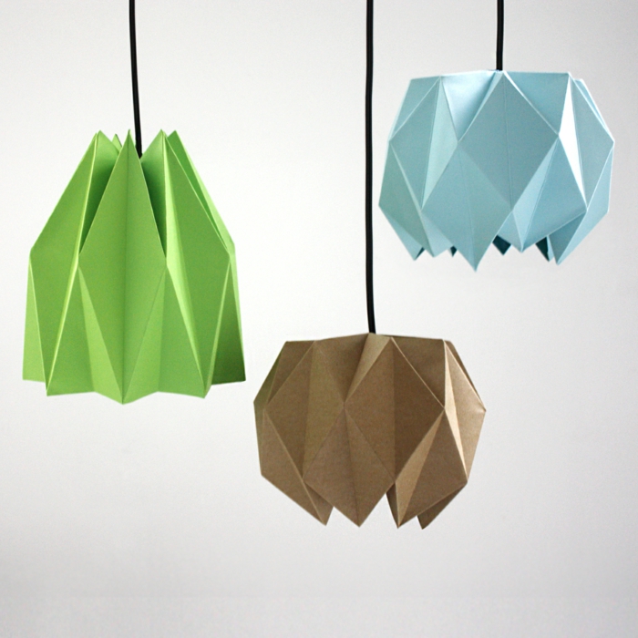 drei unterschiedliche Modelle von Origami-Lampenschirmen aus grünem, hellblauem und hellbraunem Papier