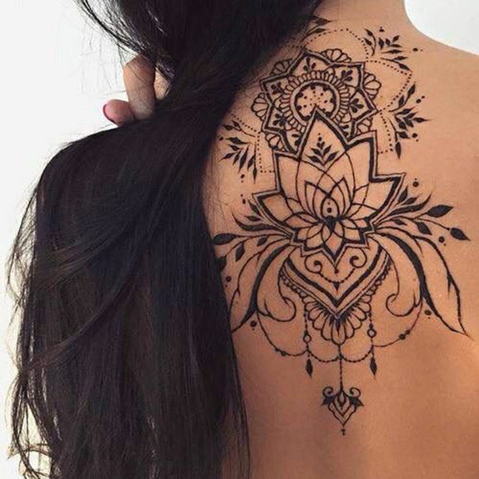 Frau mit langen dunklen Haaren mit schwarzem Rückentattoo unter dem Hals, Lotusblume aus Henna