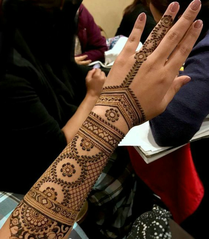 Frauentattoos am ganzen Arm und am Unterarm mit vielen kleinen Ornamenten aus Henna Farbe, Ringfinger Tattoo