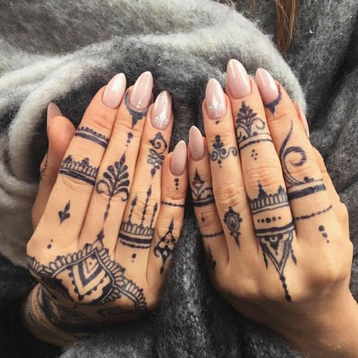 Frau mit Fingertattoos auf den beiden Händen, indische Henna Tattoo-Style mit vielen Punkten in schwarz