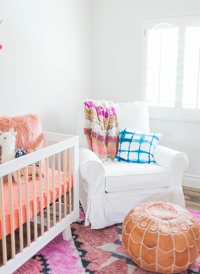 babyzimmer mädchen. ideen, weißes interieur mit lila und rosa dekorationen, babybett, sessel und bodenkissen