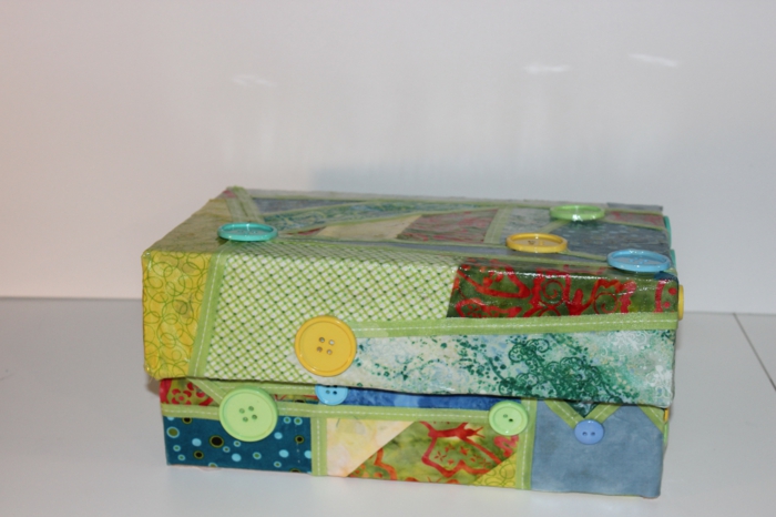 Basteln mit Karton - ein Collage aus Geschenkpapier und Knöpfen auf dem Karton