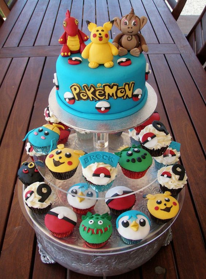 ausgefallene kleine pokemon kuchen mit verschiedenen pokemon wesen und eine blaue pokemon torte mit einem gelben pikachu, drachen pokemon und gelben überschriften 