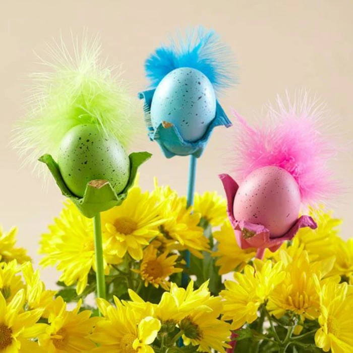 drei Eierbecher in verschiedene Farben mit Feder - rosa, blau und grün