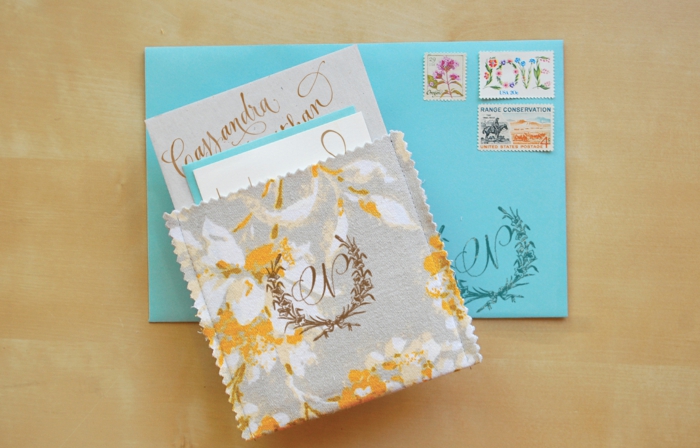DIY Einladung für Hochzeit: blauer Kartenumschlag mit Postmarken, Stoffumschlaf aus Musterpapier in Gelb, Weiß und Grau