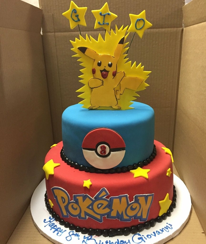 schöne zweistöckige pokemon torte mit gelben sternen und überschriften und einem kleinen pokemon wesen pikachu 
