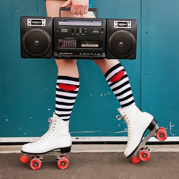 80er Kleidung - sportliche Kleidung, kurze Hose, lange Socken mit Streifmuster, weiße Rollschuhe, Boomboxer