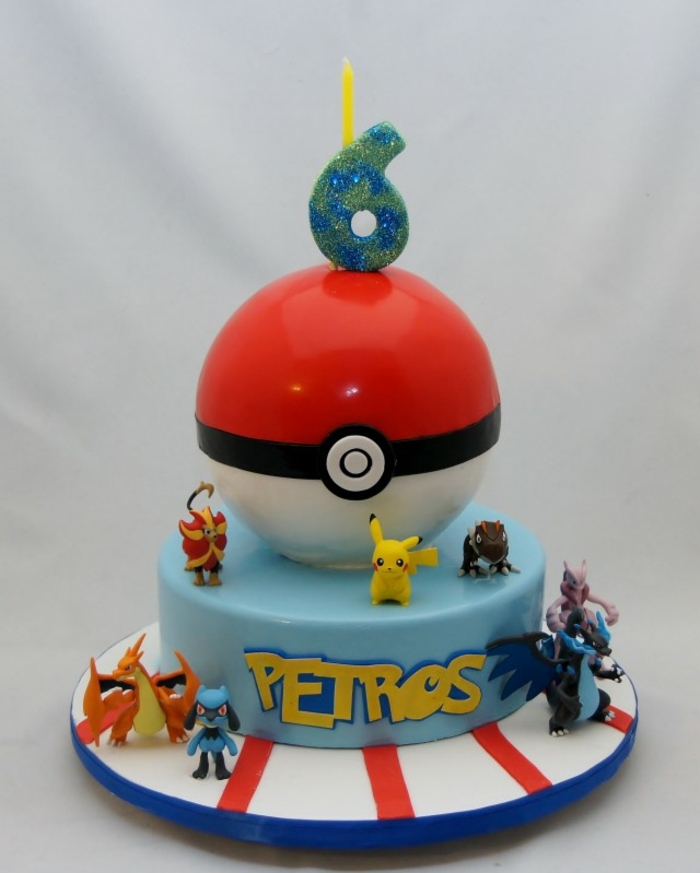 schön aussehende pokemon torte mit einem großen roten pokeball und kleinen verschiedenen pokemon wesen, ein gelbes pikachu und drachen pokemon, dragon pokemon 