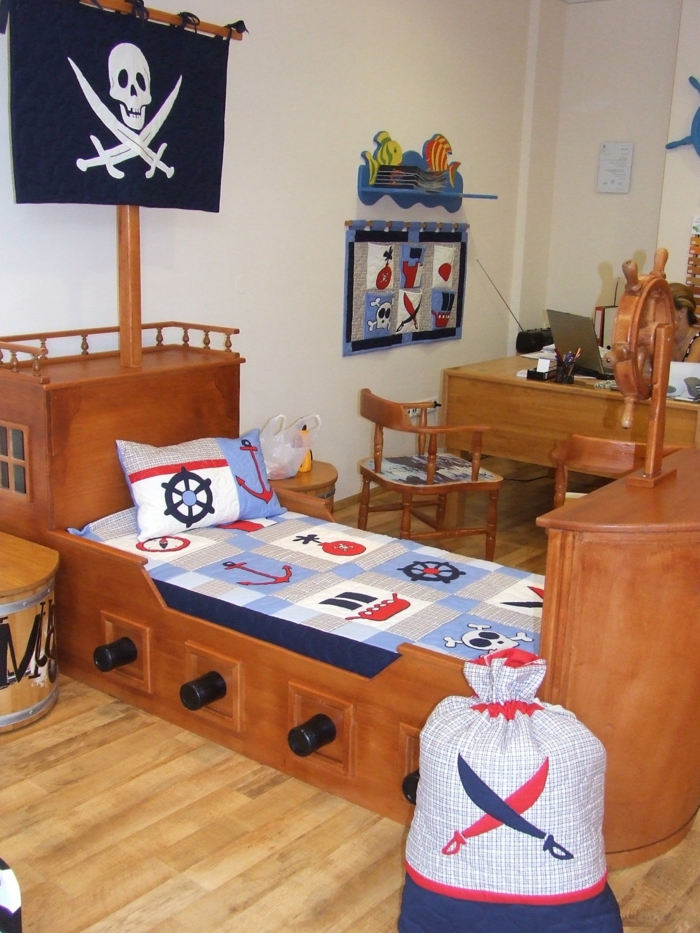 ein Bett wie Schiff mit Totenkopf Symbol und ein Sack für die Spielzeuge, Schreibtisch am Hintergrund
