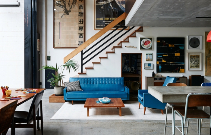 blaues Sofa und Sessel kleiner Tisch Bilder an der Wand - 50er Jahre Deko