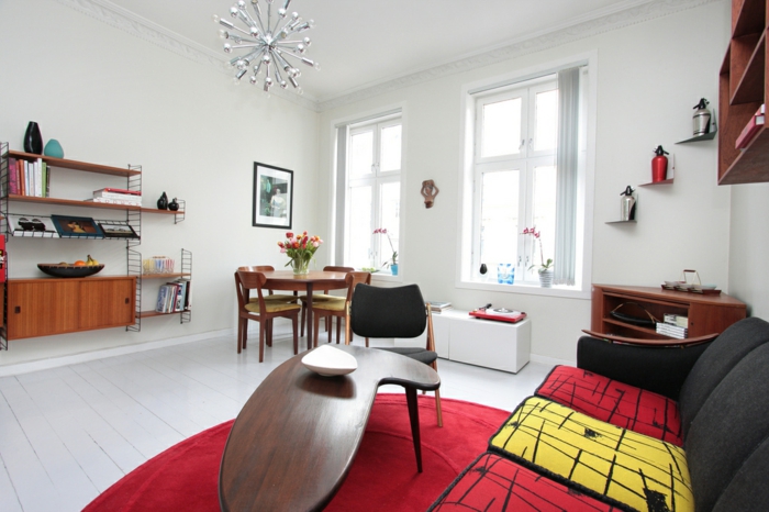 eine kleine Wohnung mit retro Deko Essecke mit vier Stühlen, kleiner ausgefallener Tisch, gepolstertes Sofa