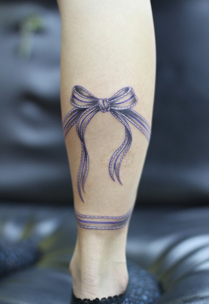 tattoo an der wade, lila baendchen, weibliche tattoo motive, bein tattoo