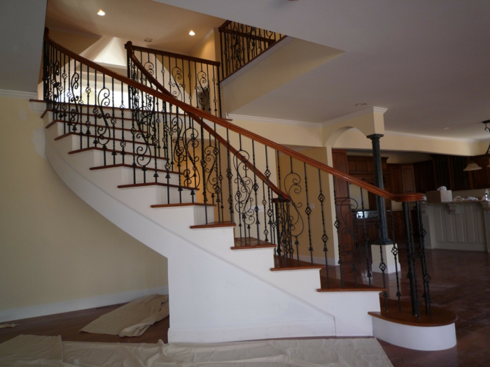 weiße Treppen, hölzerne Brüstung, eiserne Stocke - Treppenaufgang gestalten