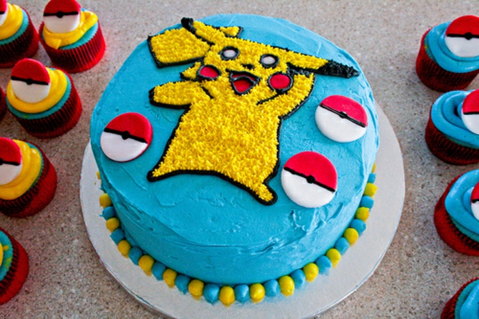 noch ein teller mit einer blauen pokemon torte mit pikachu und kleinen roten pokebällen und pokemon kuchen 