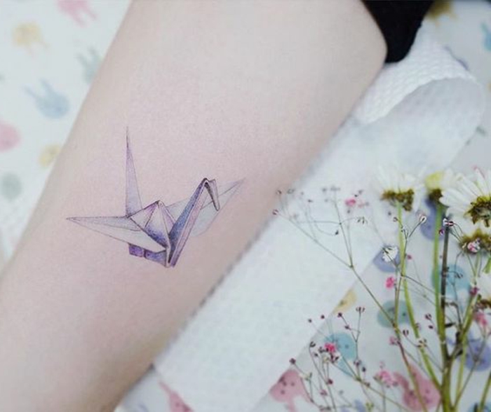 gier ist eine idee für einen origami tattoo - ein fliegender origami vogel - tattoo origami auf der hand und blumen