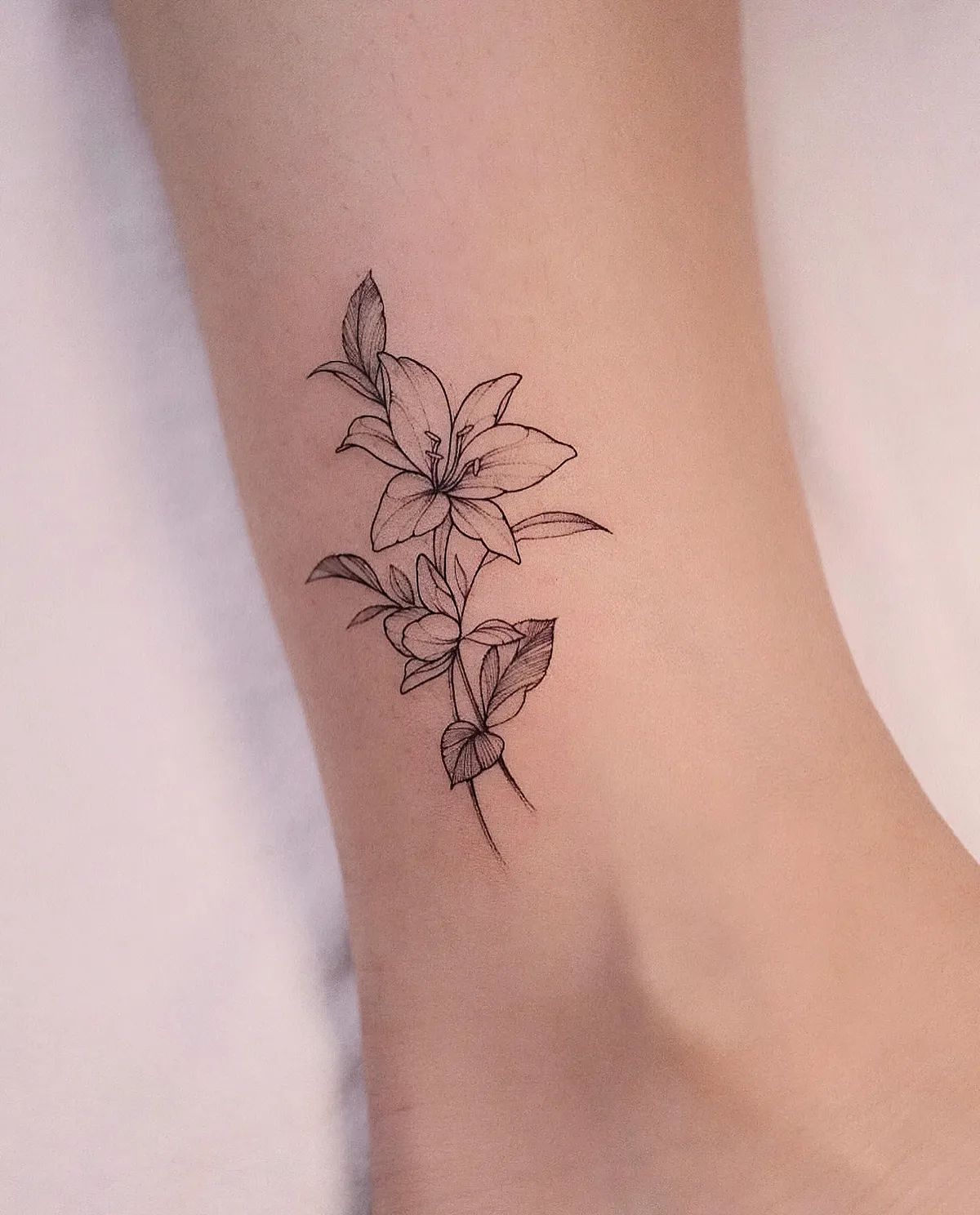 blumen tattoo am knöchel weibliches motiv lilium