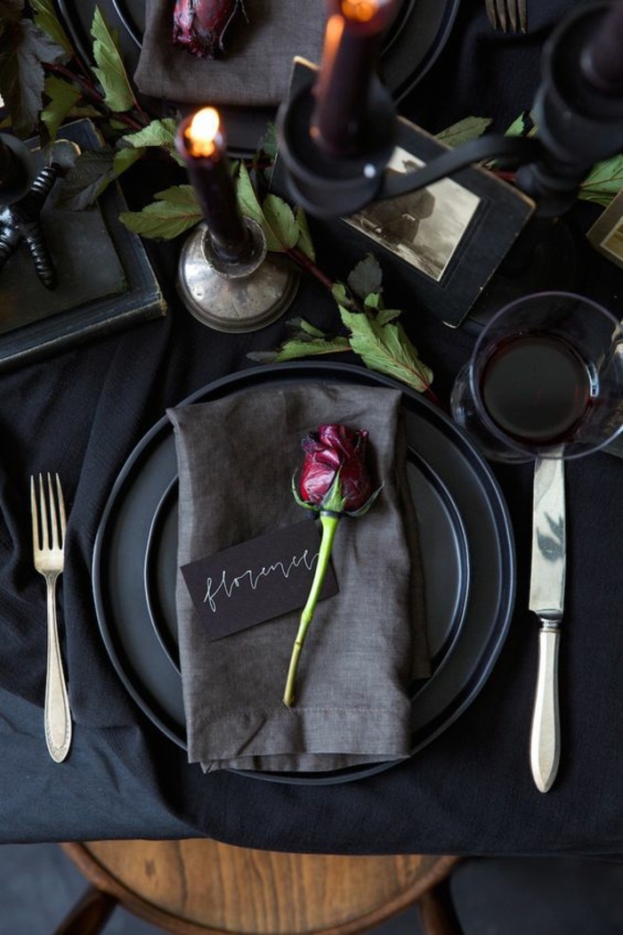 festliche tischdeko in schwarz, graue serviette, rose, besteck, kerze