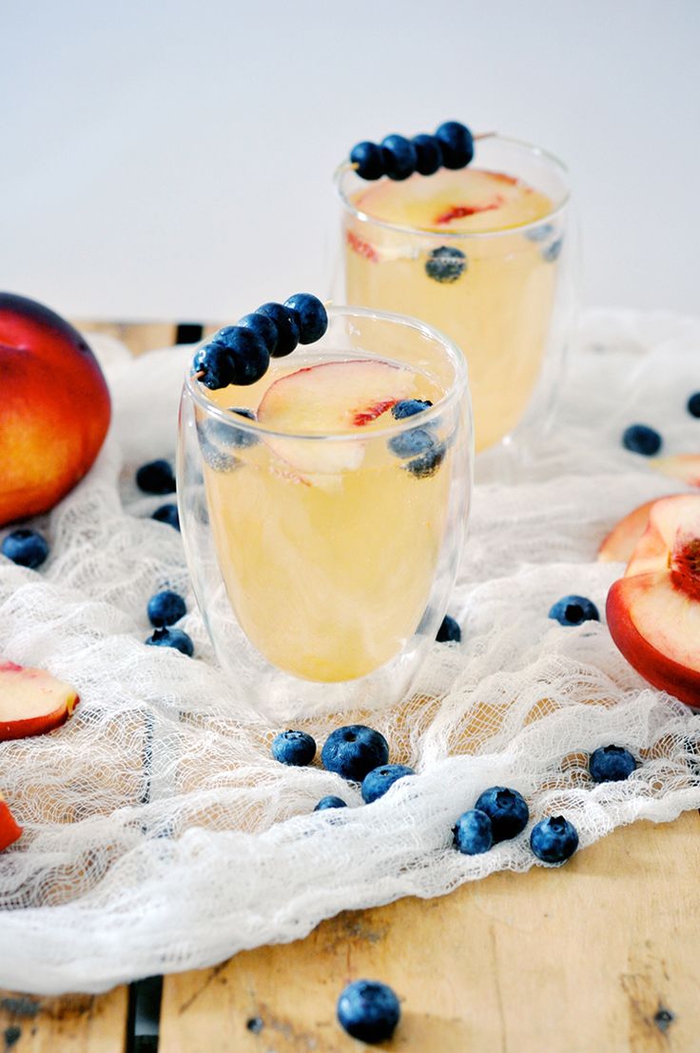 Cocktails mit Pfirsich selber machen, Gläser mit Blaubeeren dekoriert, süß und lecker